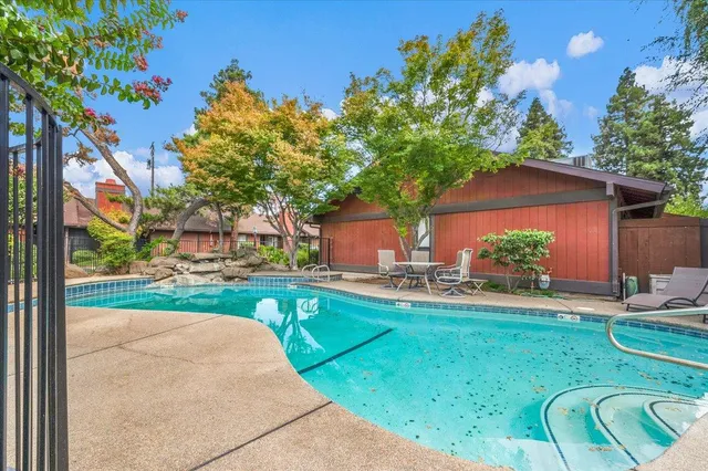 a view of a backyard with table and chairs potted plants and a palm tree