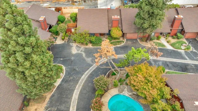 an aerial view of a house with a yard and tennis court