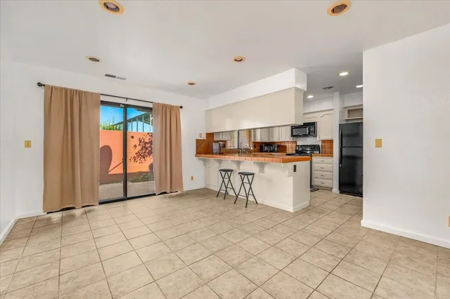 a kitchen with stainless steel appliances kitchen island granite countertop a refrigerator and a stove top oven