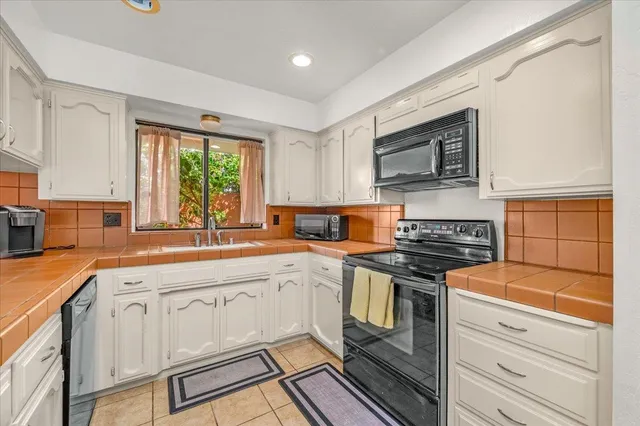 a kitchen with stainless steel appliances granite countertop a stove and a sink