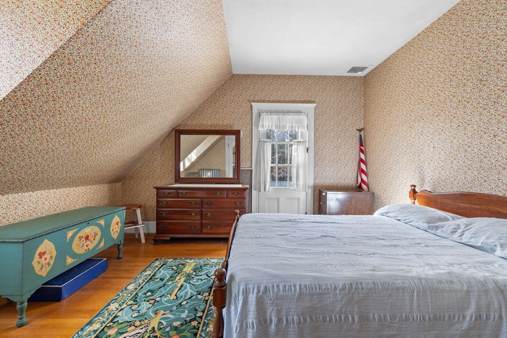 27 Locust Avenue Lexington, MA 02421 - Photo 16 of 38 a bedroom with a bed and wooden floor