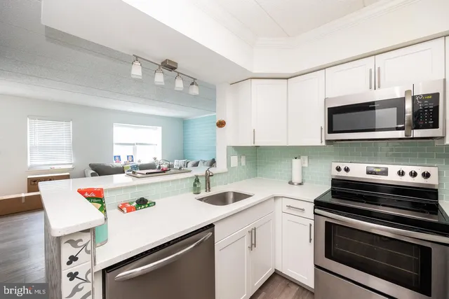 a kitchen with kitchen island a stove a sink and a microwave