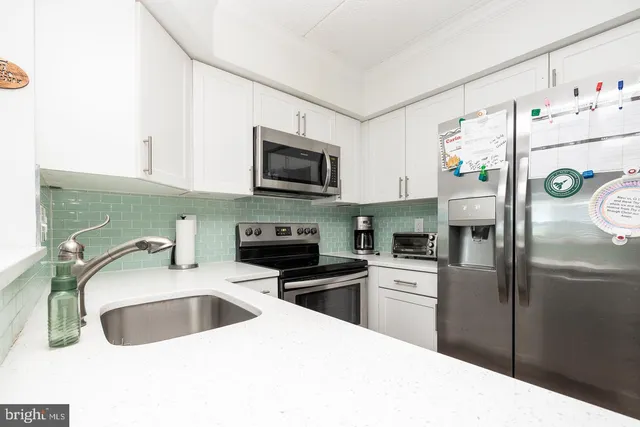a kitchen with a sink a microwave a refrigerator and cabinets