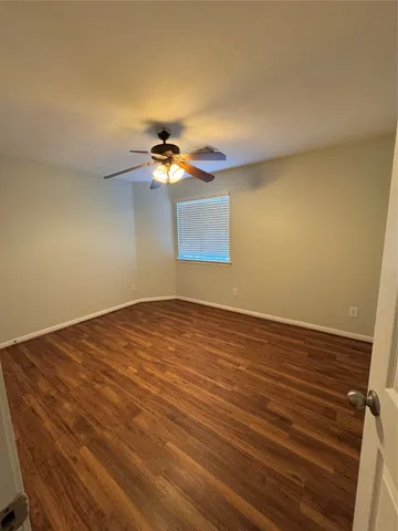 a view of an empty room with a chandelier fan