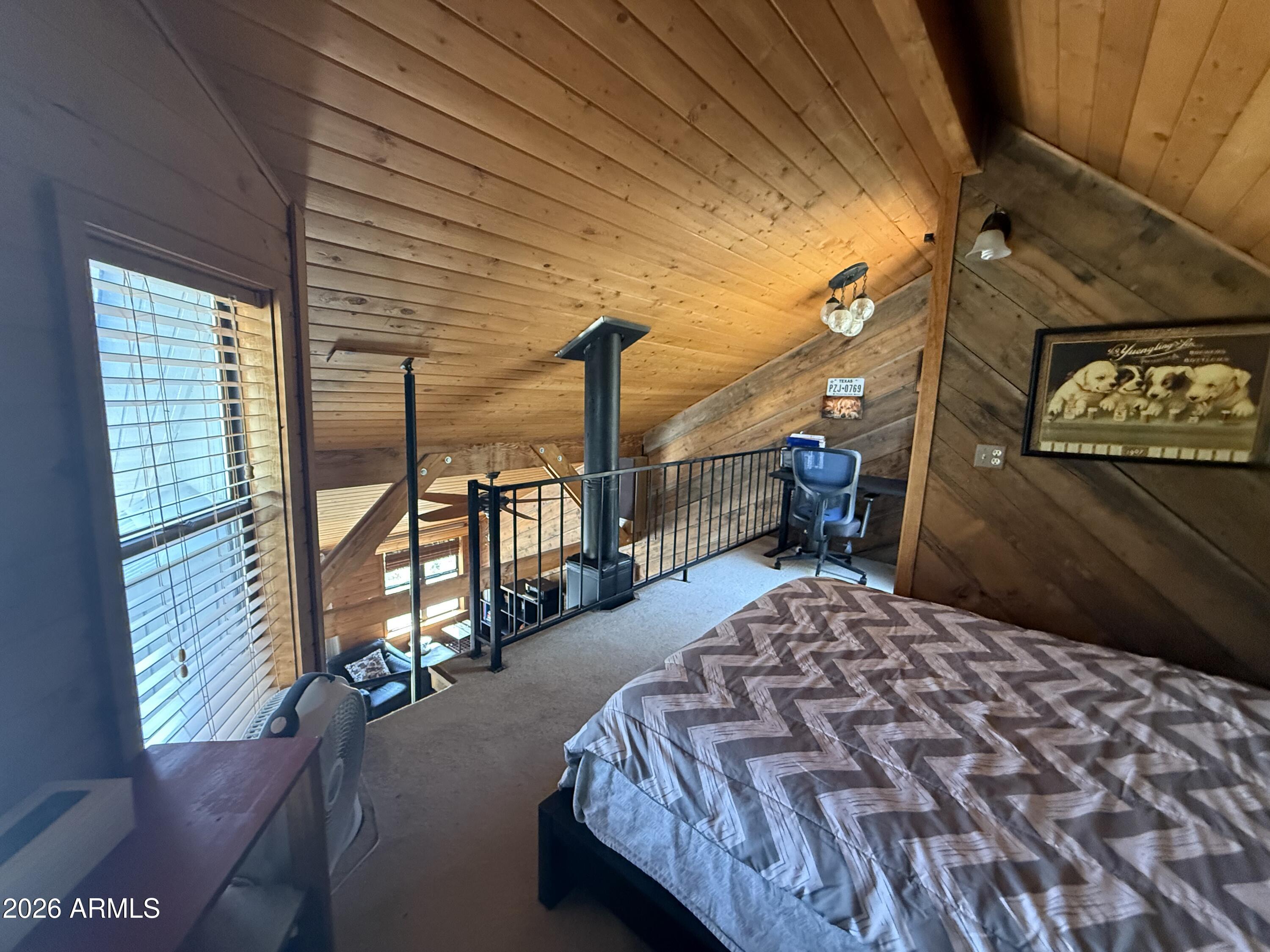 6687 Mountain View Road Crown King, AZ 86343 - Photo 9 of 18 a bedroom with a bed and wooden floor