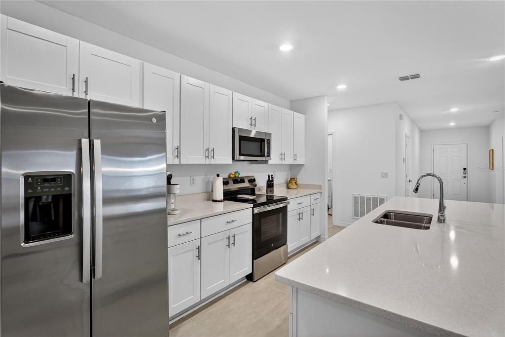 317 Riverfront Way Edgewater, FL 32141 - Photo 17 of 63 a kitchen with a refrigerator a microwave a sink and cabinets