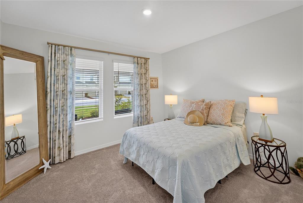 317 Riverfront Way Edgewater, FL 32141 - Photo 4 of 63 a bedroom with a bed and a lamp next to a window