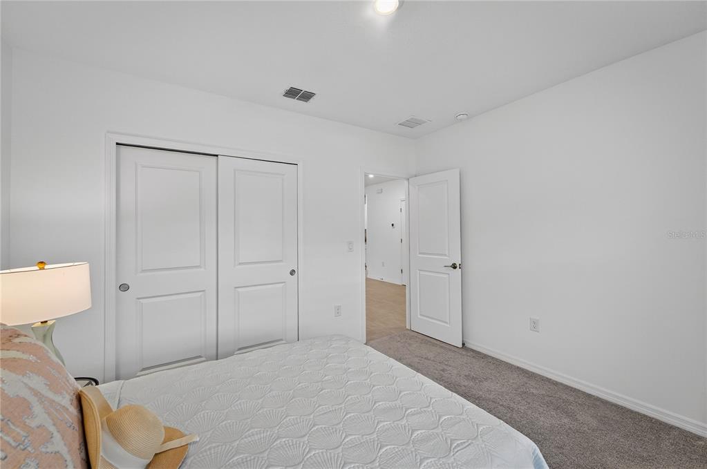 317 Riverfront Way Edgewater, FL 32141 - Photo 5 of 63 a room with a bed and a lamp on desk