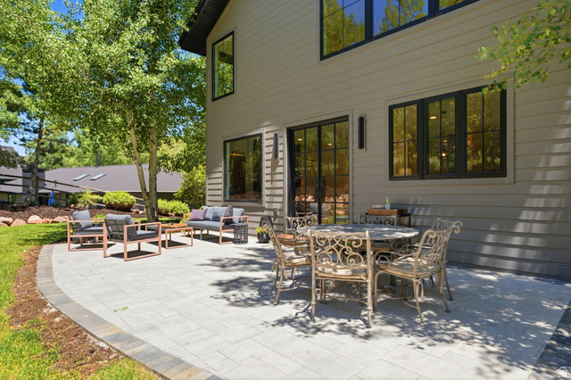 3027 Homestead Road Park City, UT 84098 - Photo 60 of 62 Expansive outdoor patio featuring paver stone hardscaping, multiple seating areas, a glass-paned exterior door, and black-framed windows
