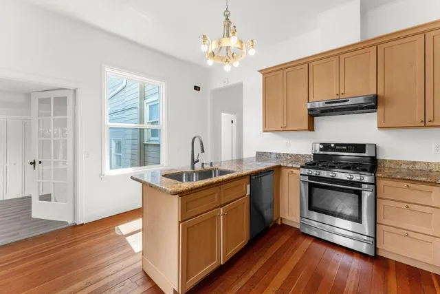 a kitchen with stainless steel appliances granite countertop a sink stove and refrigerator