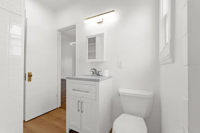 a bathroom with a toilet a sink and mirror