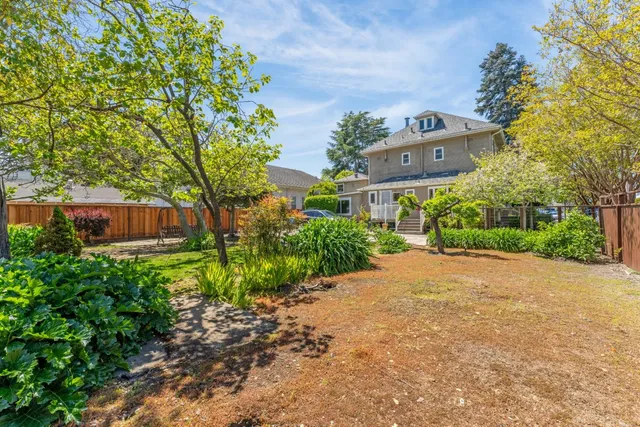 a front view of a house with a yard and a garden