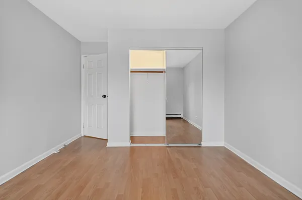 an empty room with wooden floor and closet