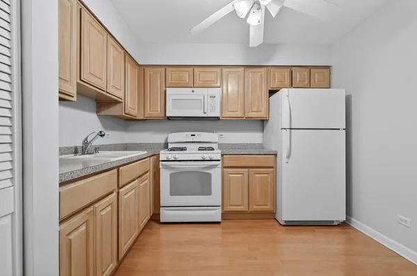 a kitchen with a refrigerator sink and cabinets