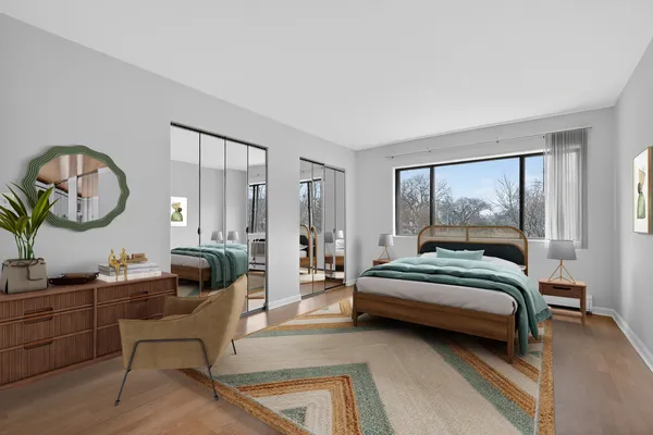 a bedroom with a bed a mirror and a large window