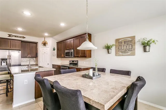 a kitchen with stainless steel appliances granite countertop a sink refrigerator and microwave