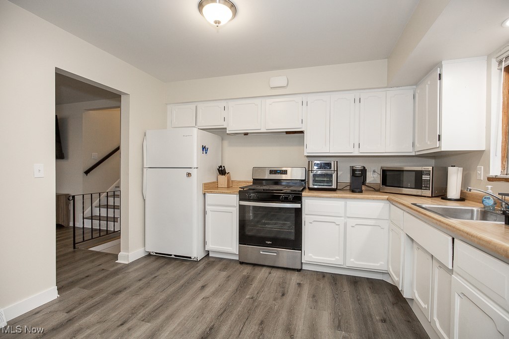4357 Valleyside Road Cleveland, OH 44135 - Photo 9 of 26 Kitchen featuring white cabinets, appliances with stainless steel finishes, wood-type flooring, and sink