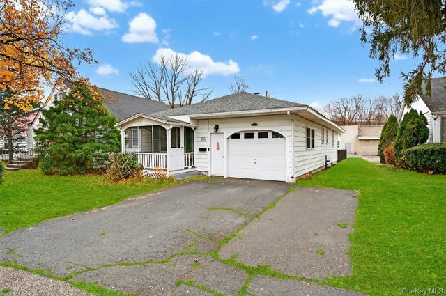 a front view of a house with a garden and yard