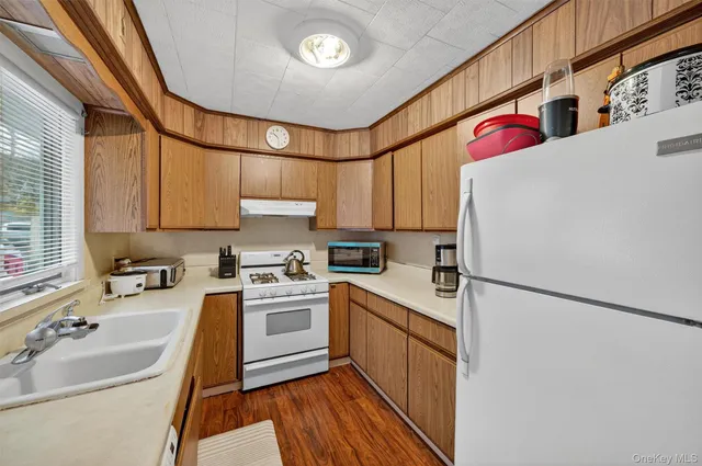 a kitchen with stainless steel appliances granite countertop a sink a stove and refrigerator