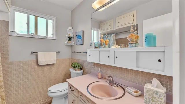 a bathroom with a granite countertop toilet sink and mirror