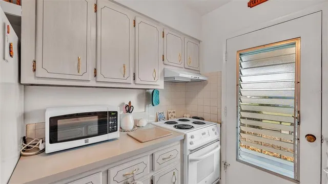 a kitchen with granite countertop white cabinets and white appliances