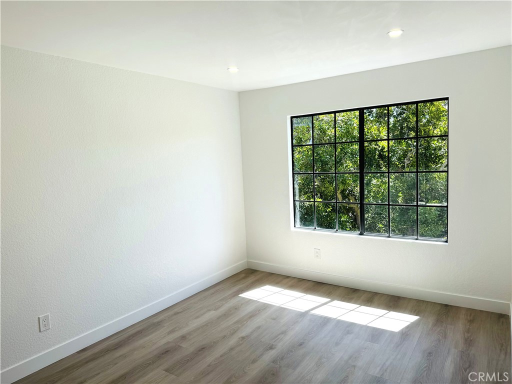 10 Sunshine, Unit 31 Irvine, CA 92603 - Photo 13 of 29 an empty room with wooden floor and windows