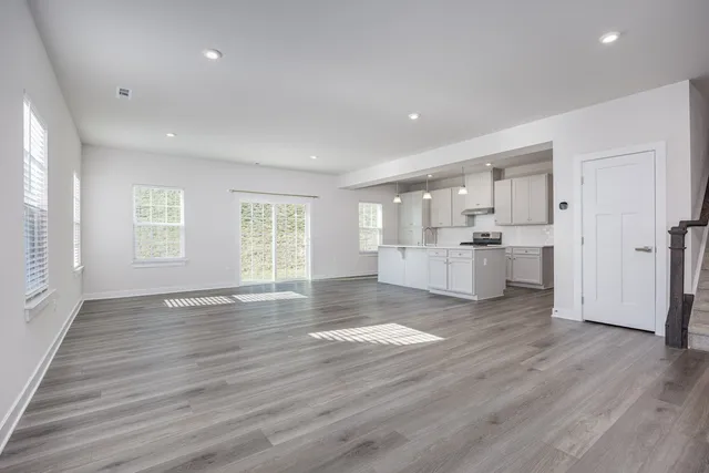 a view of empty room with wooden floor and window