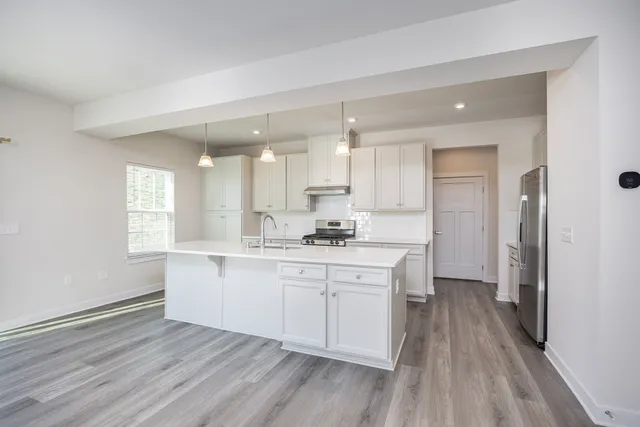 a large kitchen with a wooden floor and cabinets