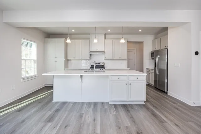 a kitchen with a refrigerator sink and cabinets