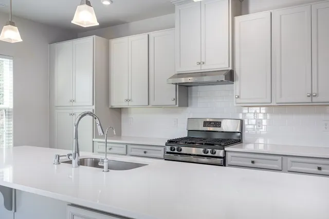 a kitchen with granite countertop white cabinets and sink