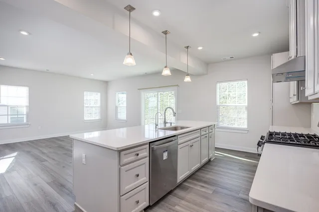 a kitchen with sink stove and refrigerator