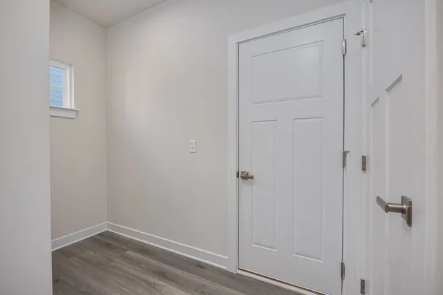 a view of a hallway with wooden floor and entryway