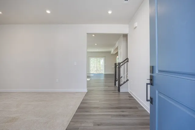 a view of a hallway with wooden floor and staircase