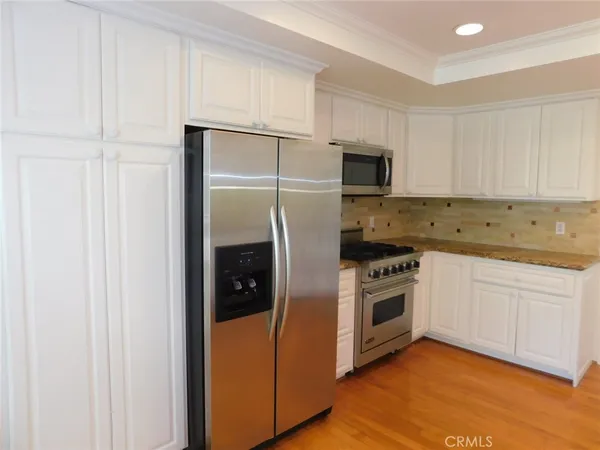 a kitchen with granite countertop white cabinets and white appliances