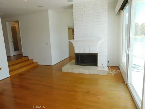 a view of an entryway with wooden floor and a fireplace