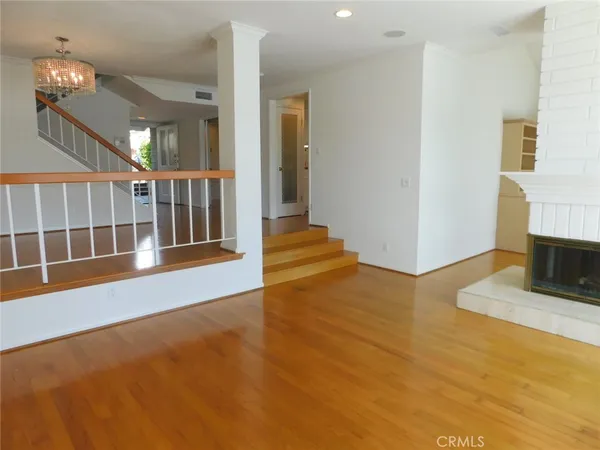 a view of a livingroom with a fireplace wooden floor and window
