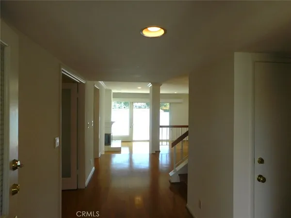 a view of a kitchen with a sink and dishwasher with wooden floor