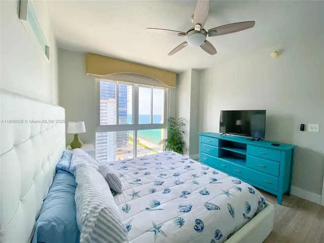 a bedroom with a bed a flat screen tv and a couch