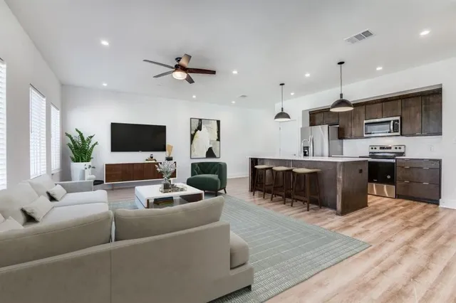 a kitchen with a sink a chandelier and wooden floor
