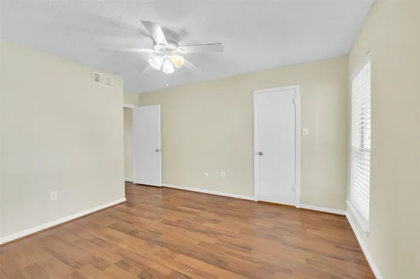 a view of an empty room with wooden floor