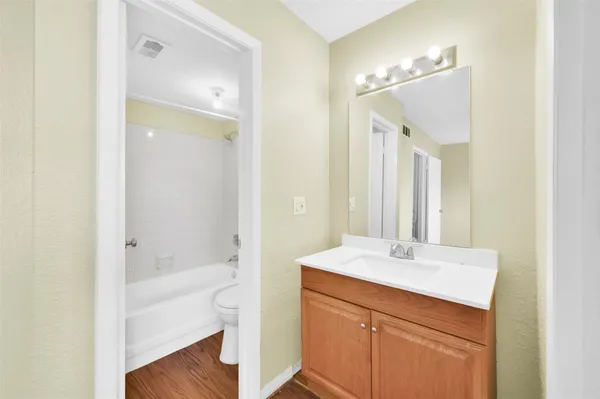 a bathroom with a bathtub shower sink vanity and mirror