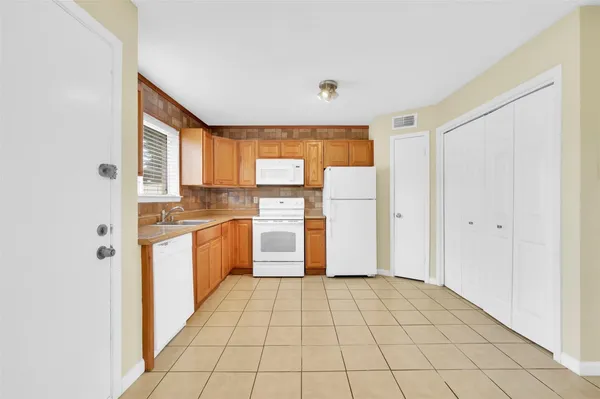 a kitchen with a refrigerator and white cabinets