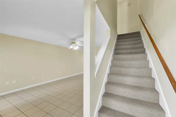 a view of staircase with white walls and railing