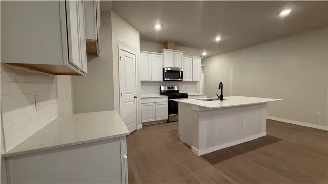 an empty room with wooden floor ceiling fan and windows