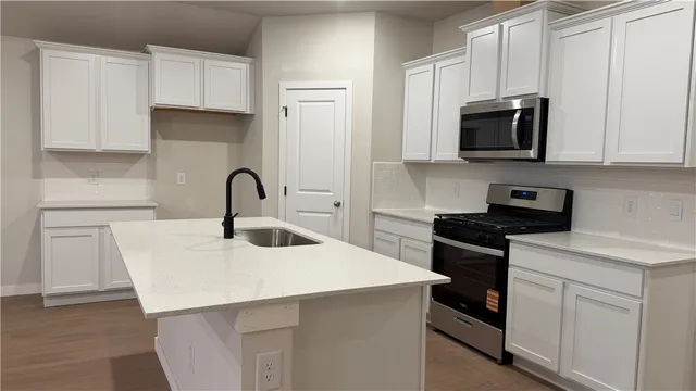 an empty room with a chandelier fan and windows