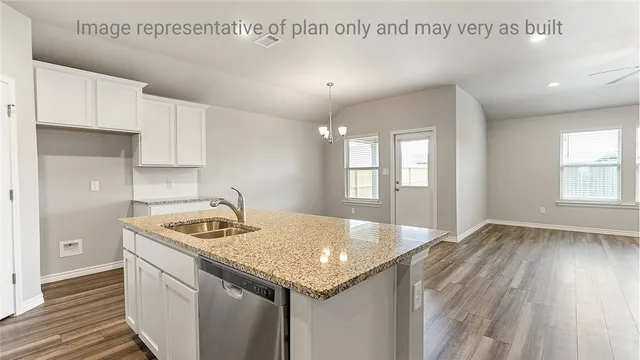 a kitchen that has a sink a stove and wooden floor