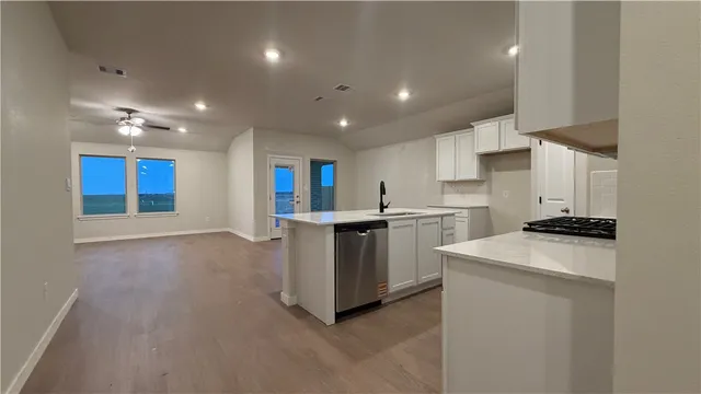 a kitchen with white cabinets and stainless steel appliances