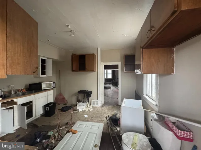 a kitchen with stainless steel appliances a stove a sink dishwasher and a refrigerator with wooden floor