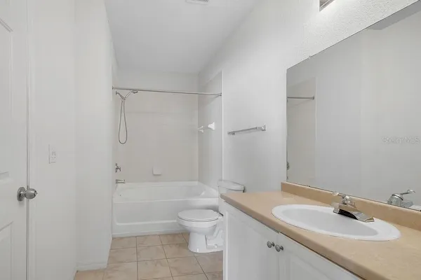 a bathroom with a granite countertop sink a toilet and shower