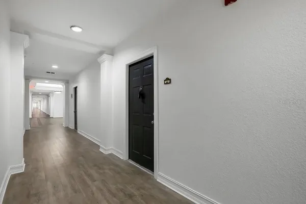 a view of a hallway with wooden floor